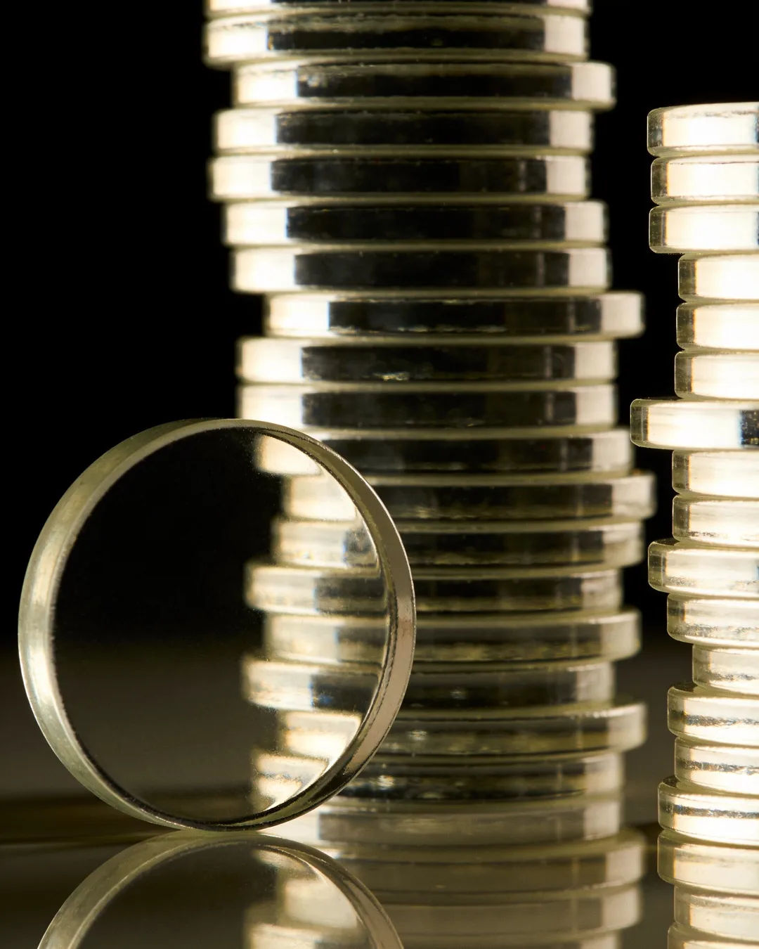 Stacks of glass tokens rising on a black ground