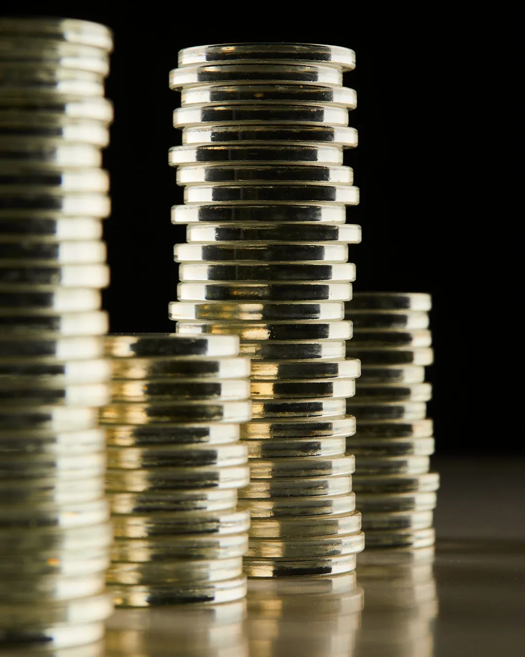 Stacks of glass tokens rising on a black ground