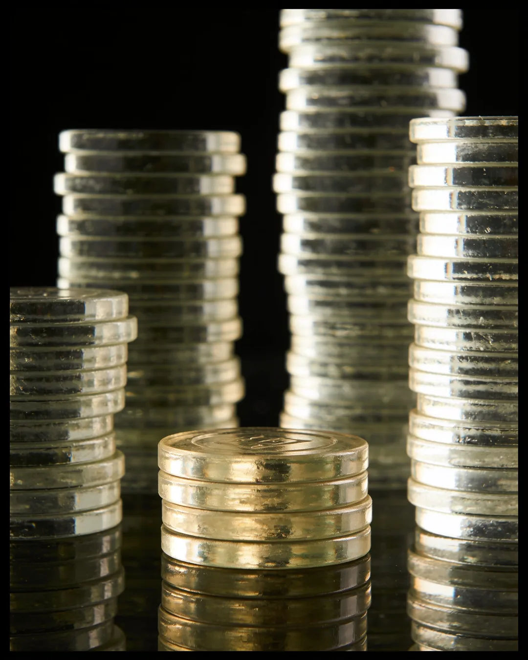 Stacks of glass tokens rising on a black ground