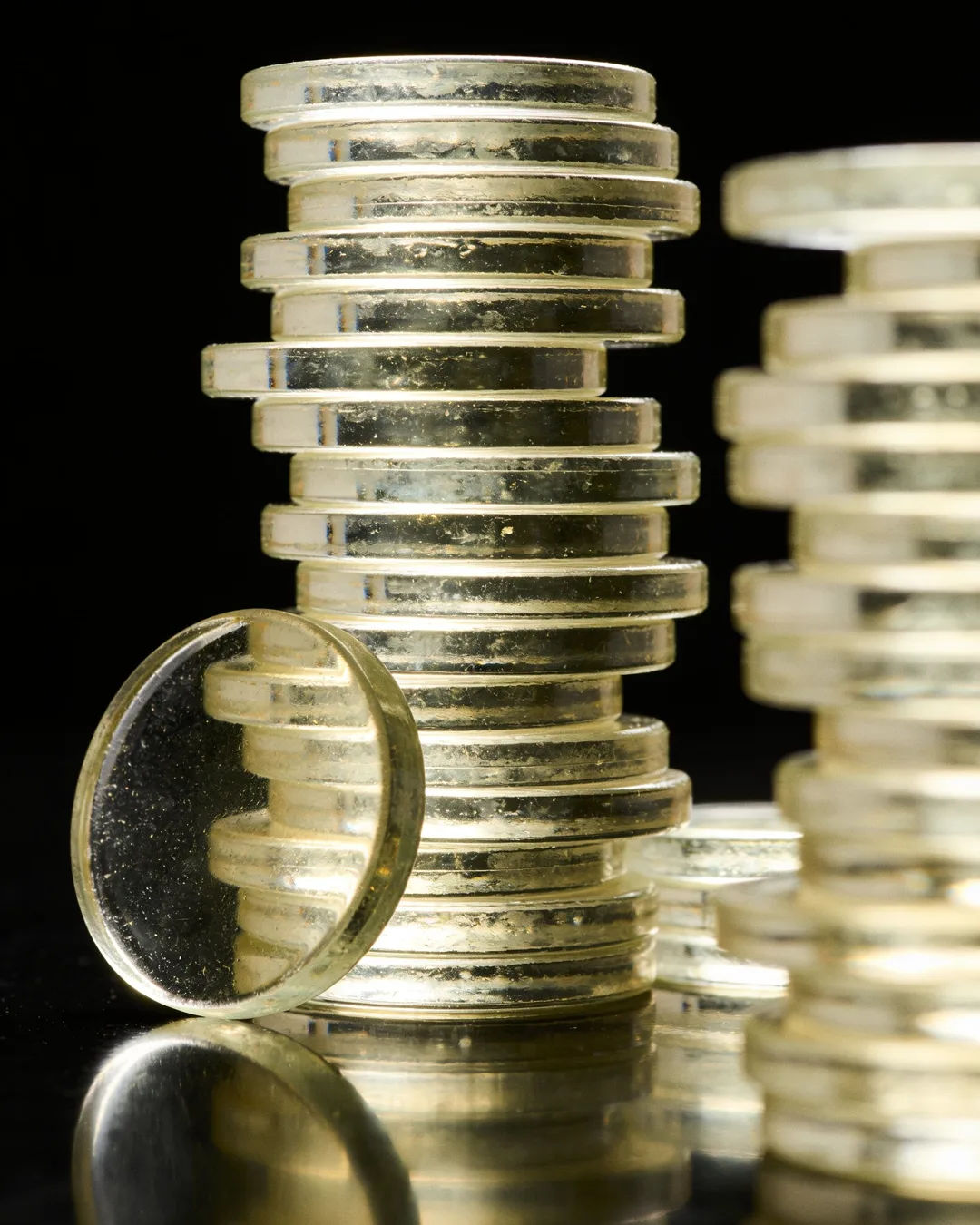 Stacks of glass tokens rising on a black ground
