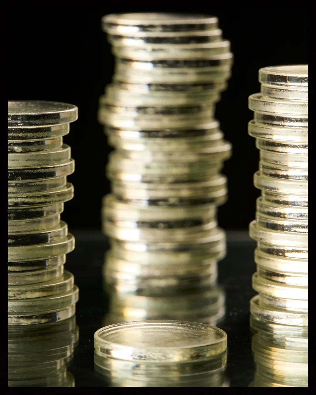 Stacks of glass tokens rising on a black ground