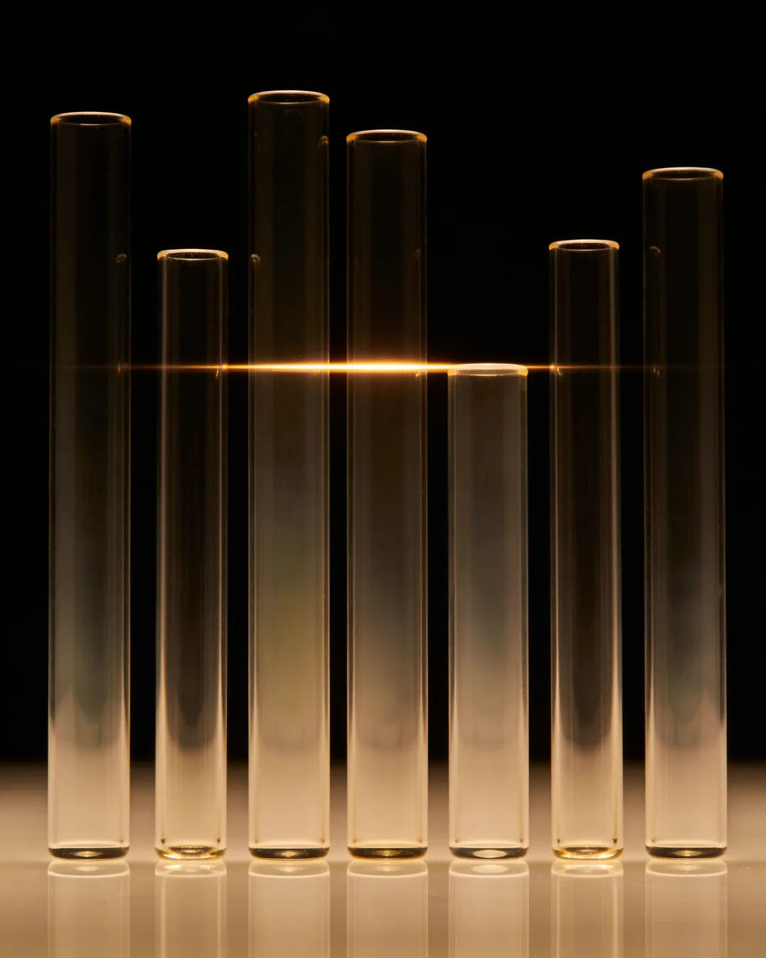 Glass columns of different heights with a glowing limit line
