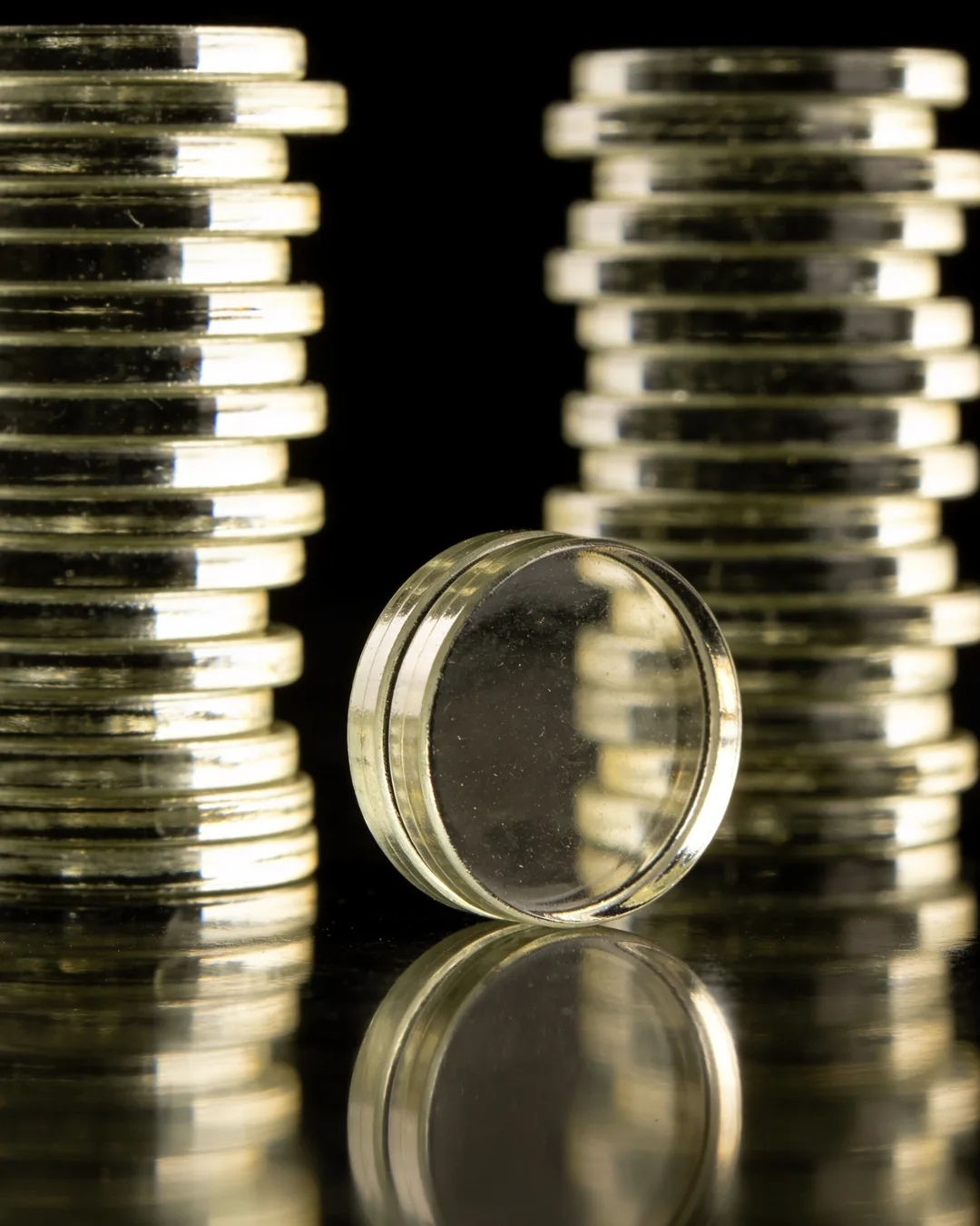 Stacks of glass tokens rising on a black ground