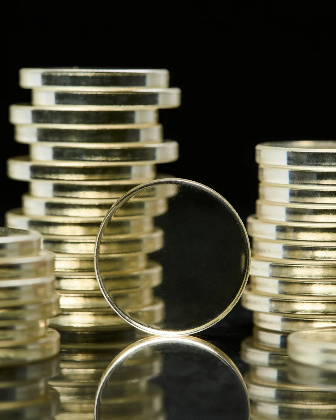 Stacks of glass tokens rising on a black ground