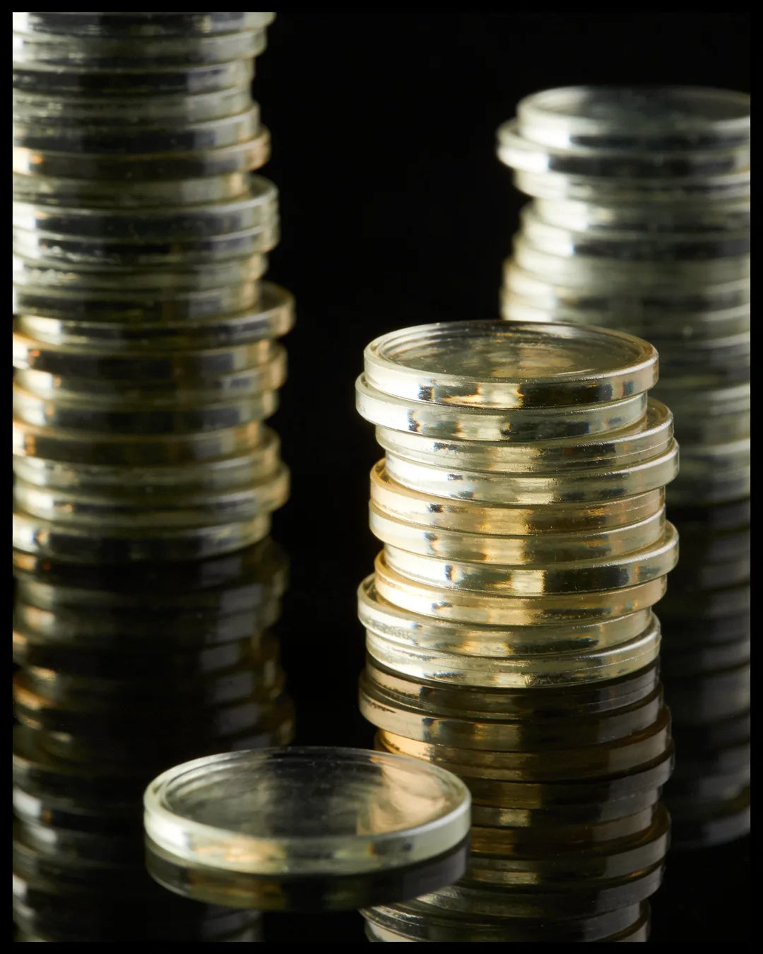 Stacks of glass tokens rising on a black ground