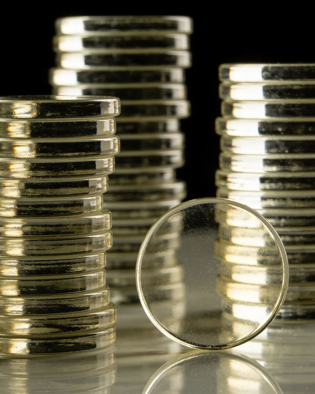 Stacks of glass tokens rising on a black ground