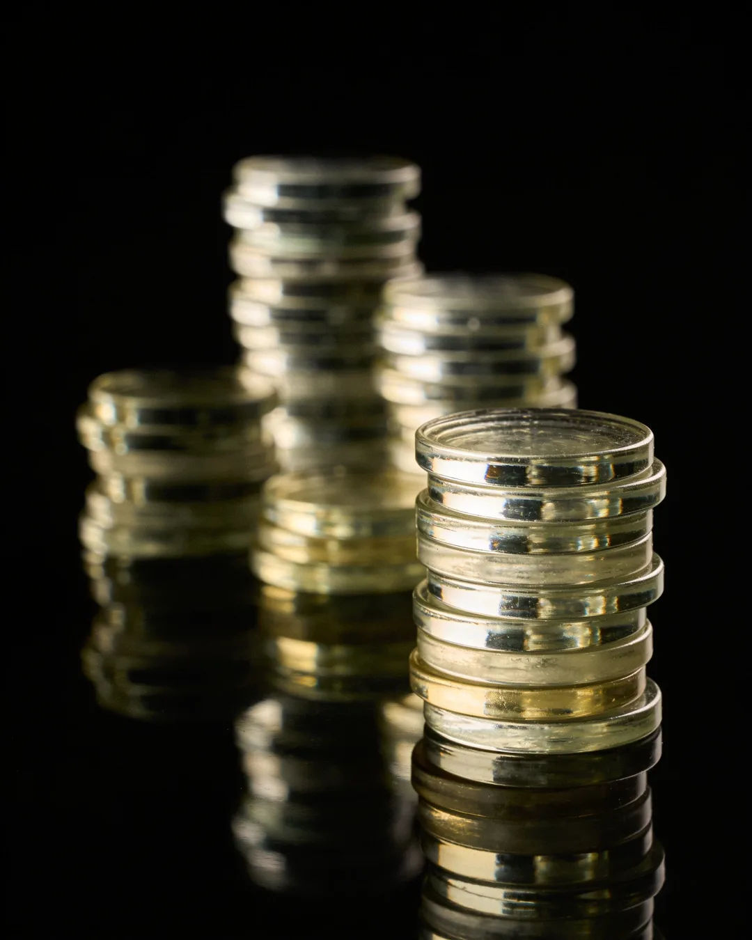 Stacks of glass tokens rising on a black ground