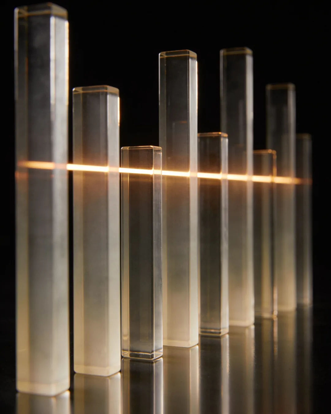 Glass columns of different heights with a glowing limit line