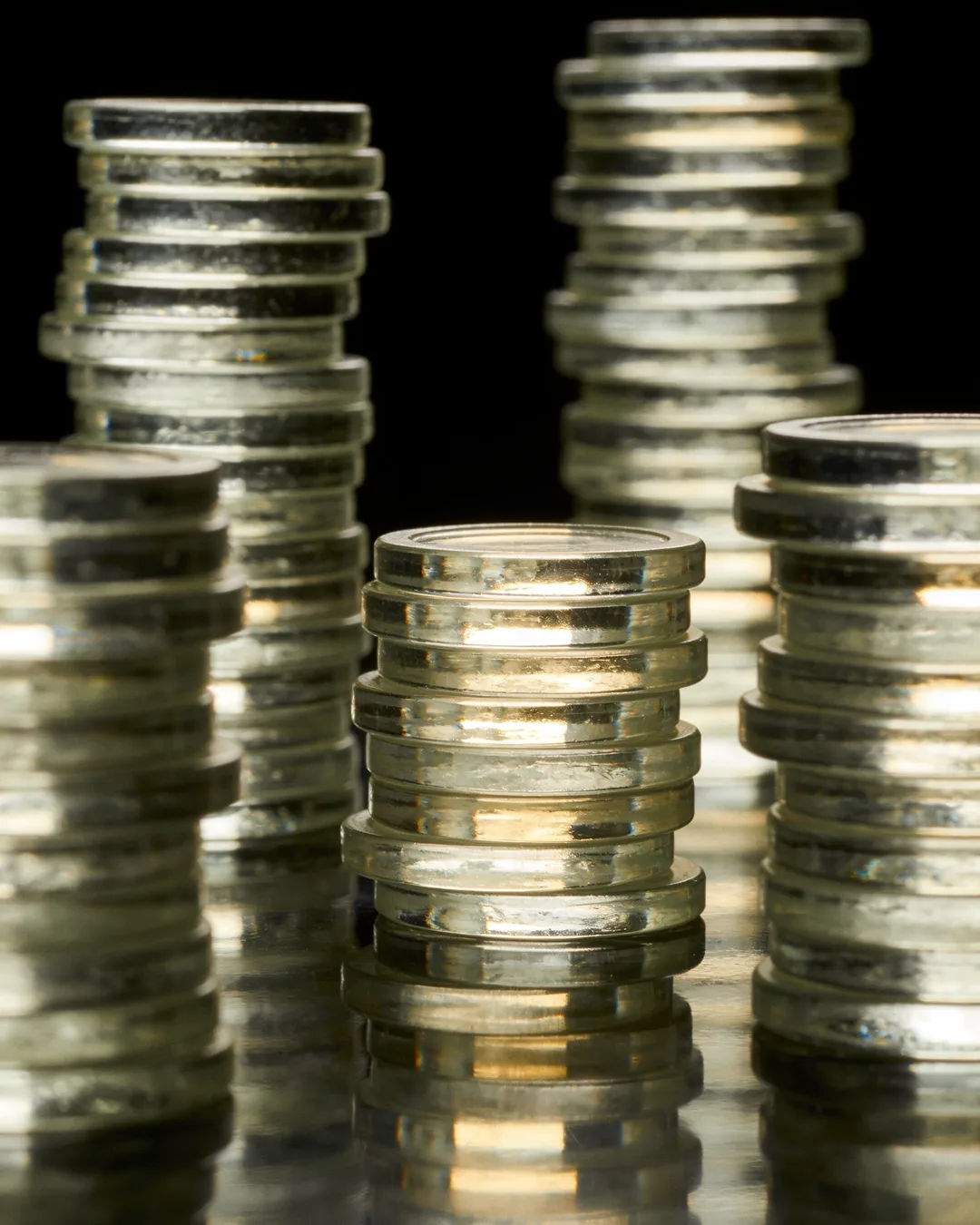 Stacks of glass tokens rising on a black ground