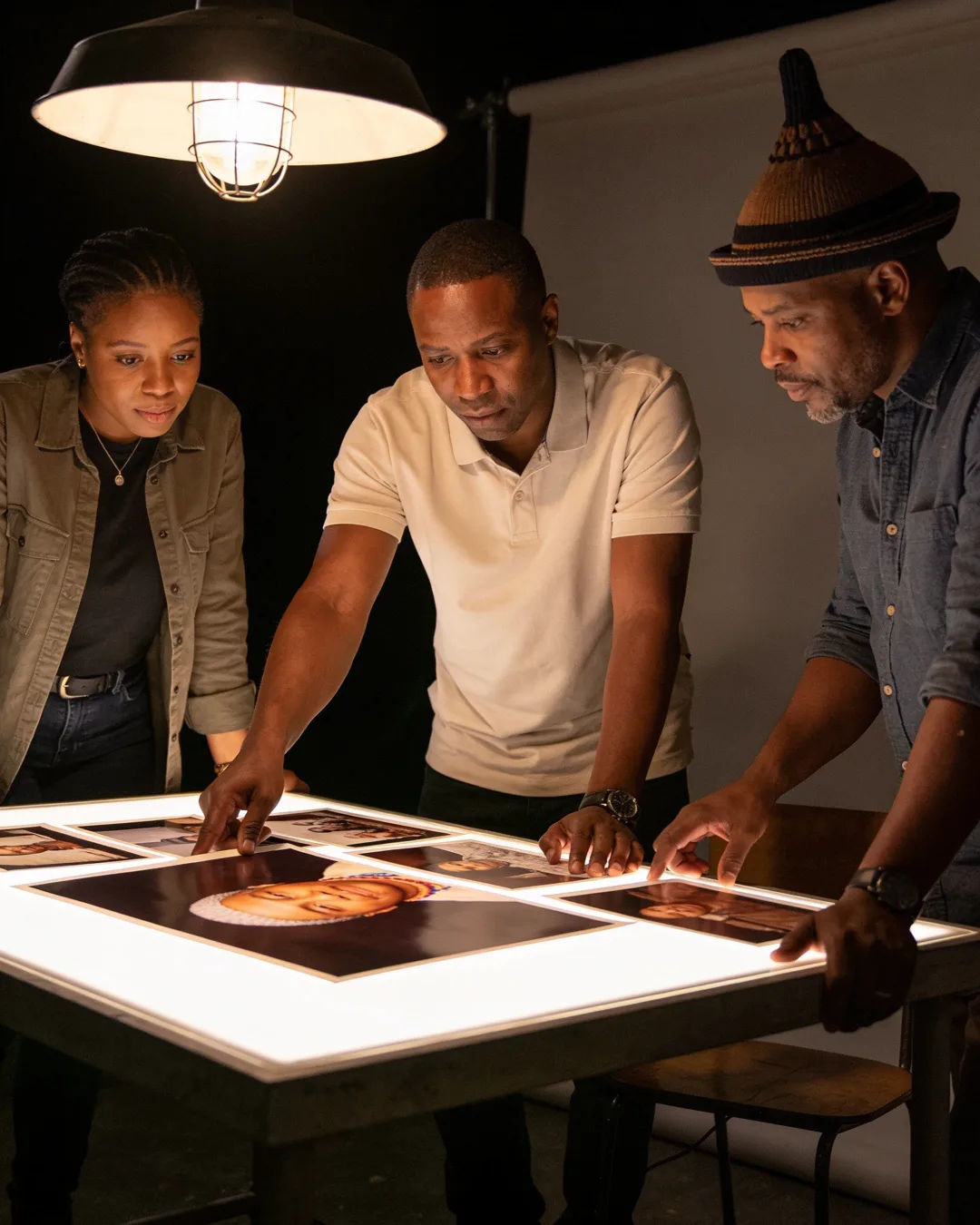 A Basotho production team reviewing printed frames on a lit table