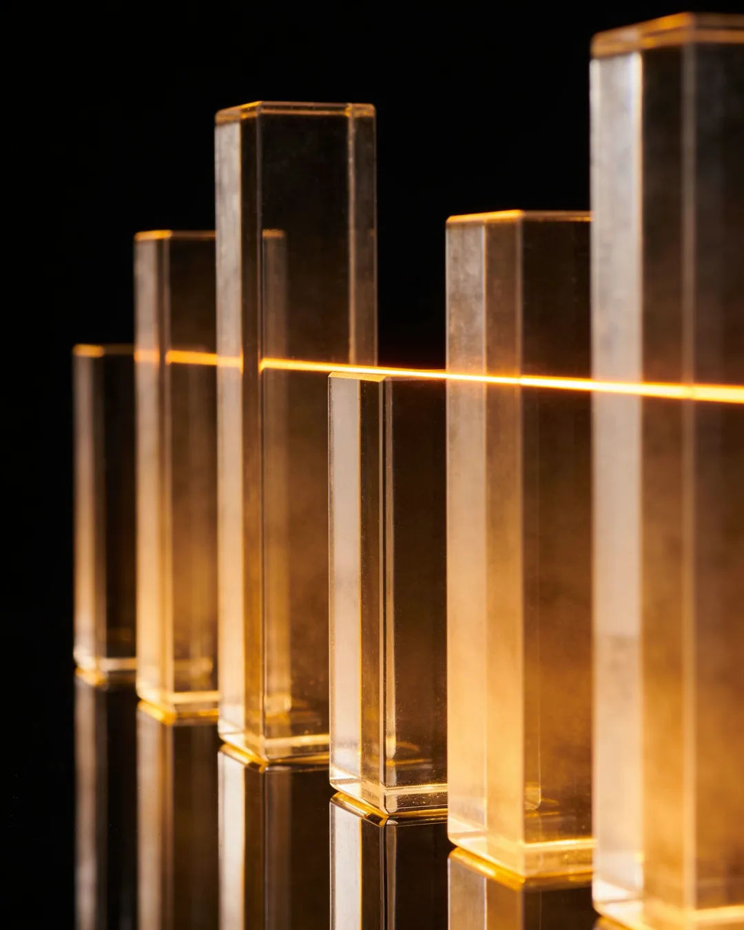 Glass columns of different heights with a glowing limit line