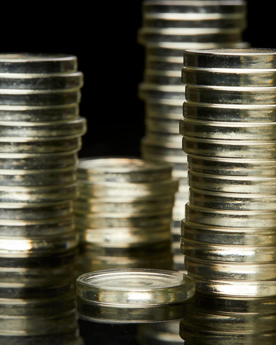 Stacks of glass tokens rising on a black ground