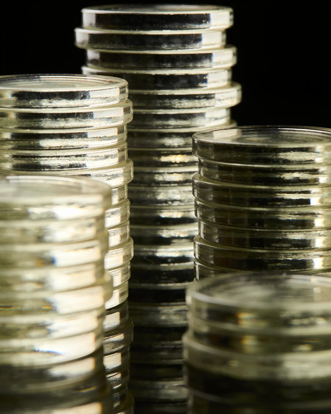 Stacks of glass tokens rising on a black ground