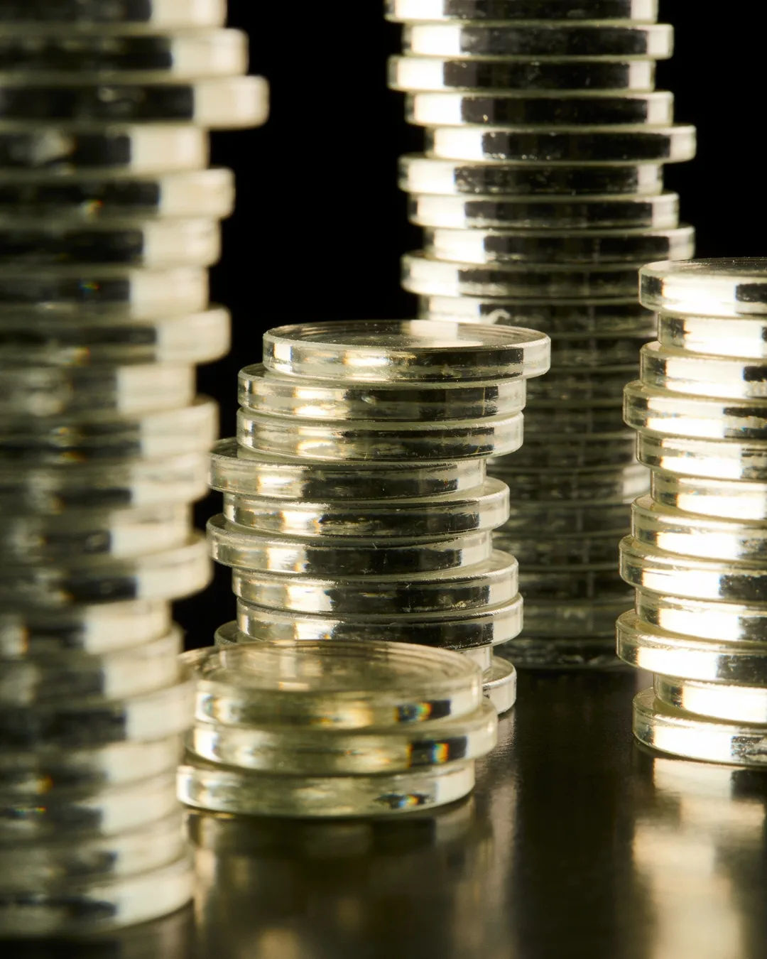 Stacks of glass tokens rising on a black ground