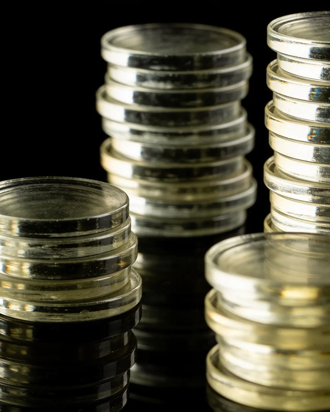 Stacks of glass tokens rising on a black ground