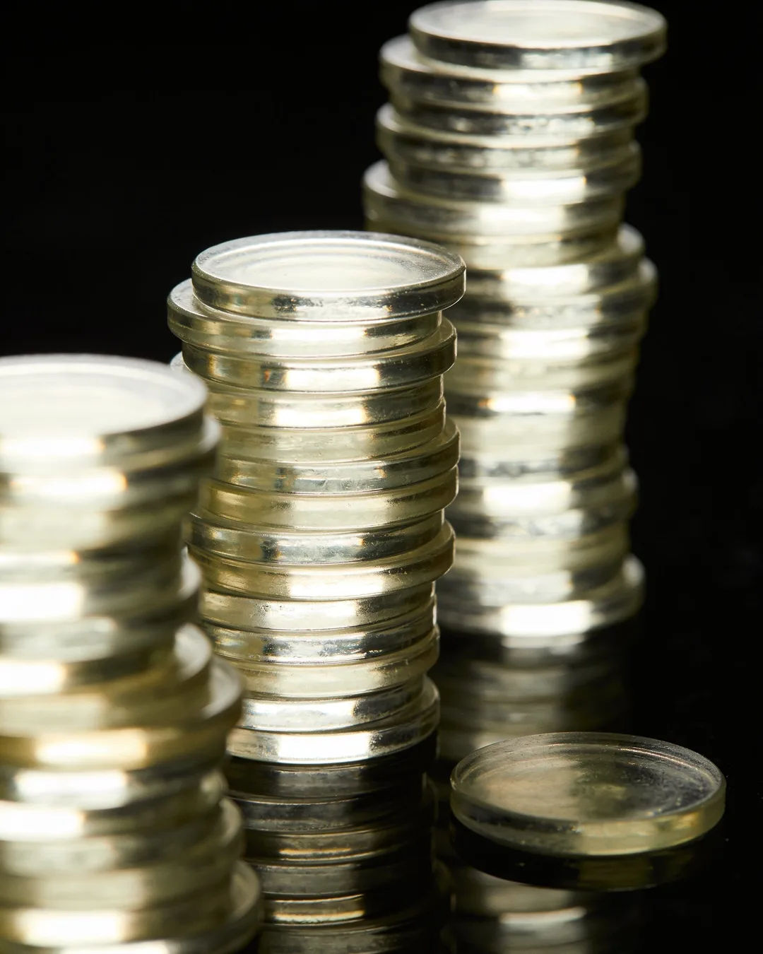 Stacks of glass tokens rising on a black ground