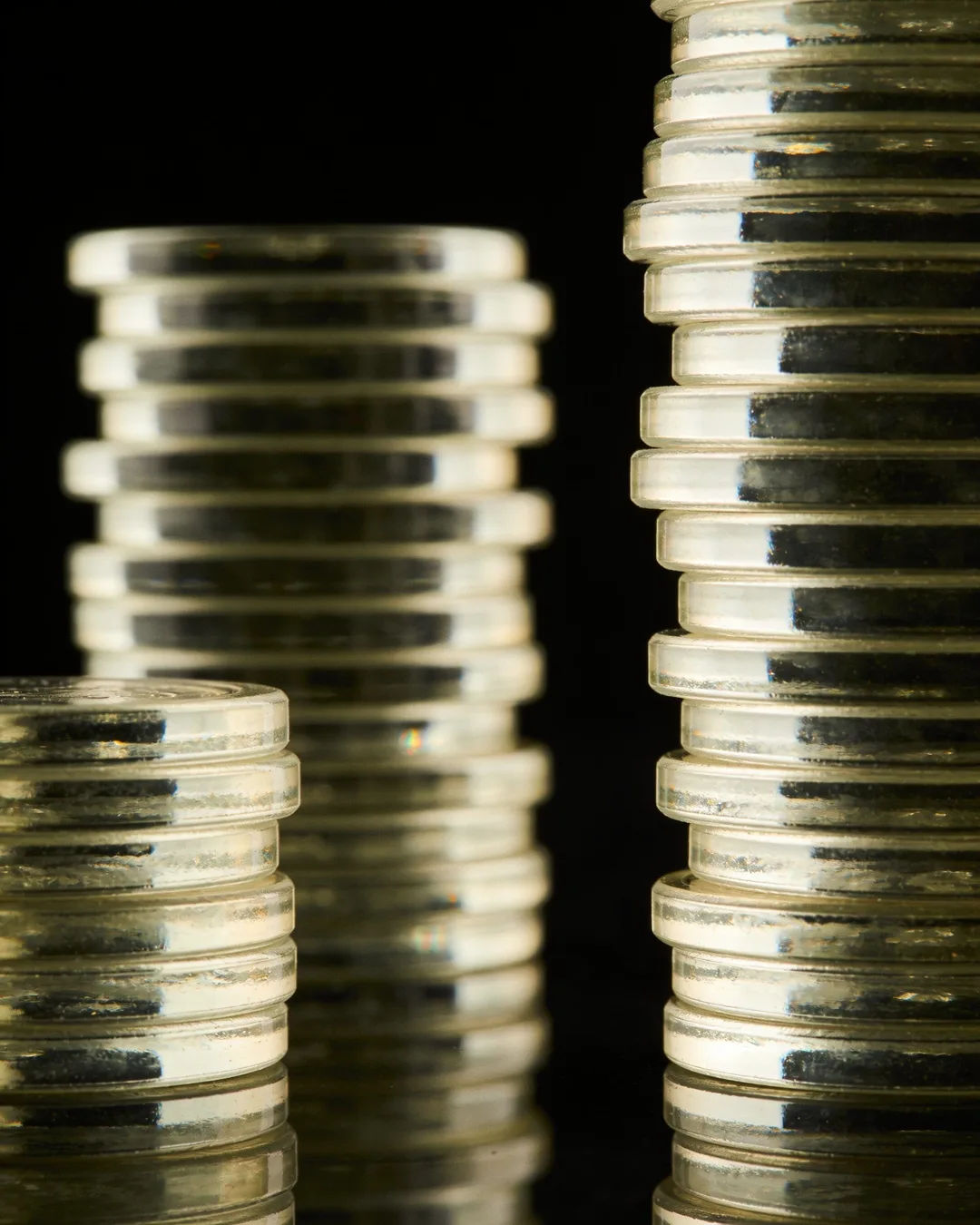 Stacks of glass tokens rising on a black ground