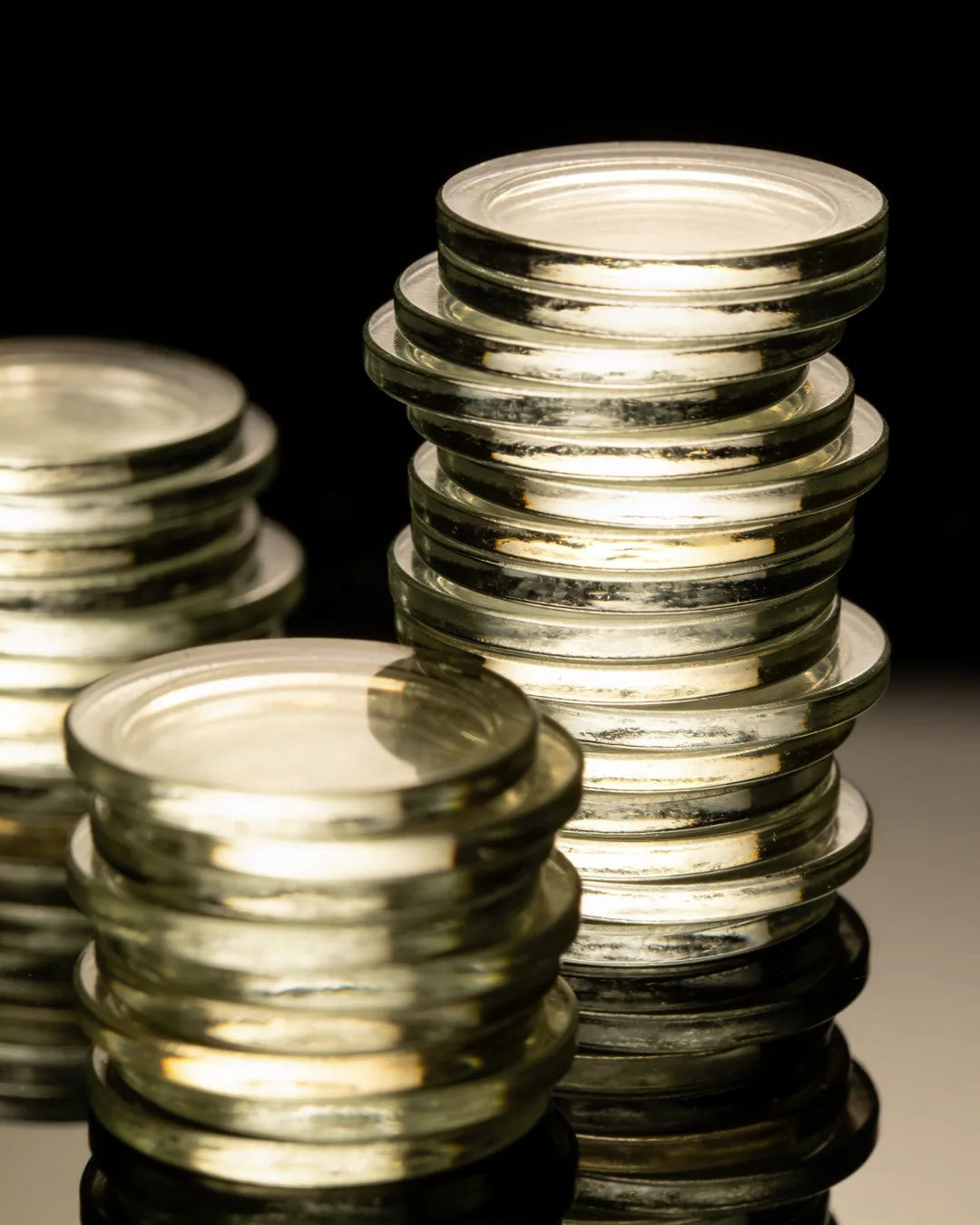 Stacks of glass tokens rising on a black ground
