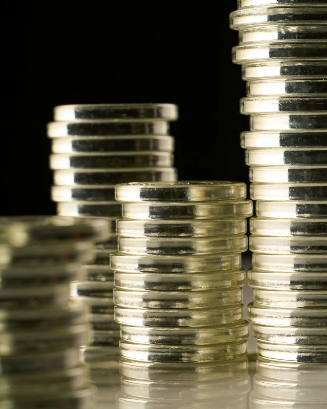 Stacks of glass tokens rising on a black ground