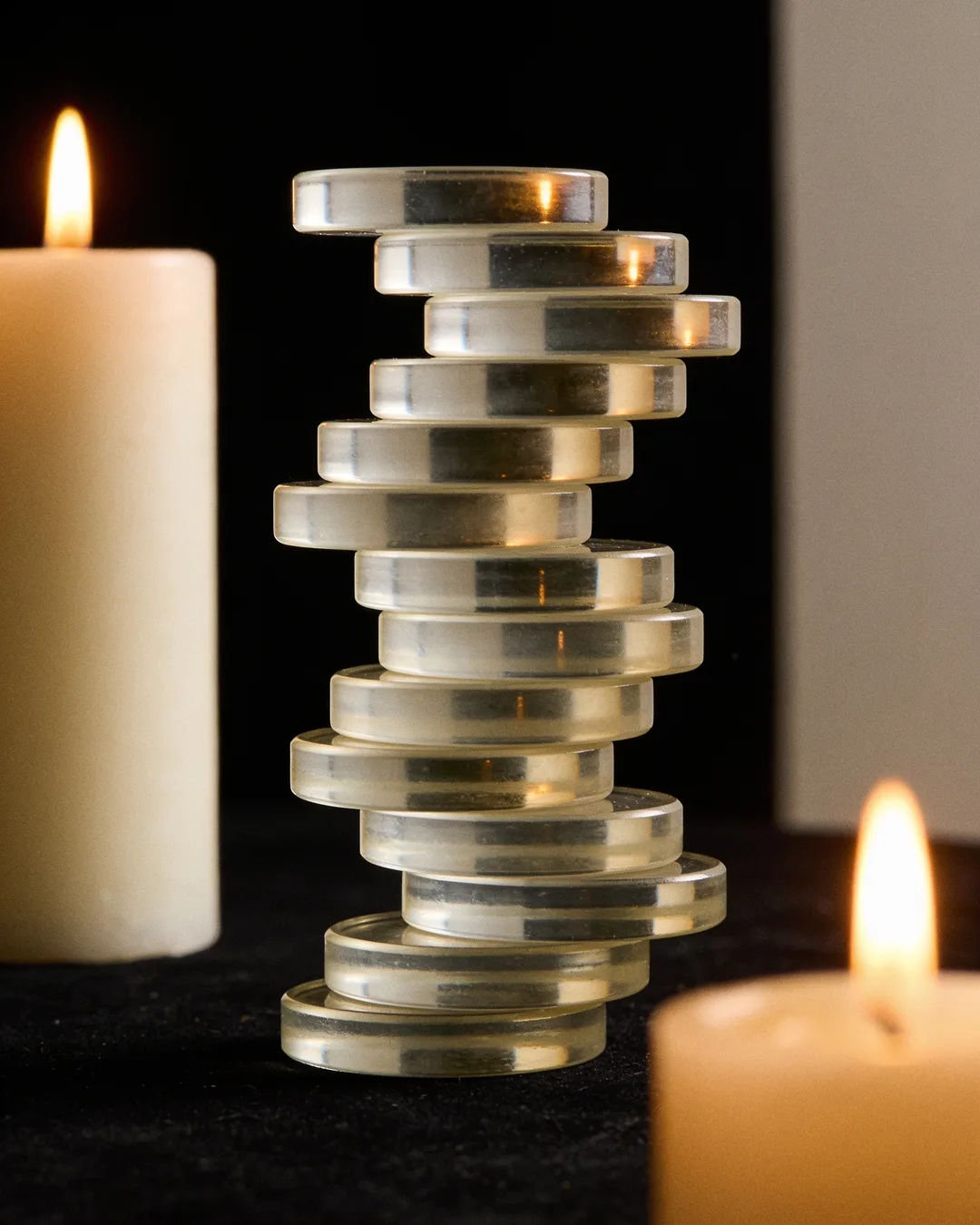 Stacks of glass tokens rising on a black ground