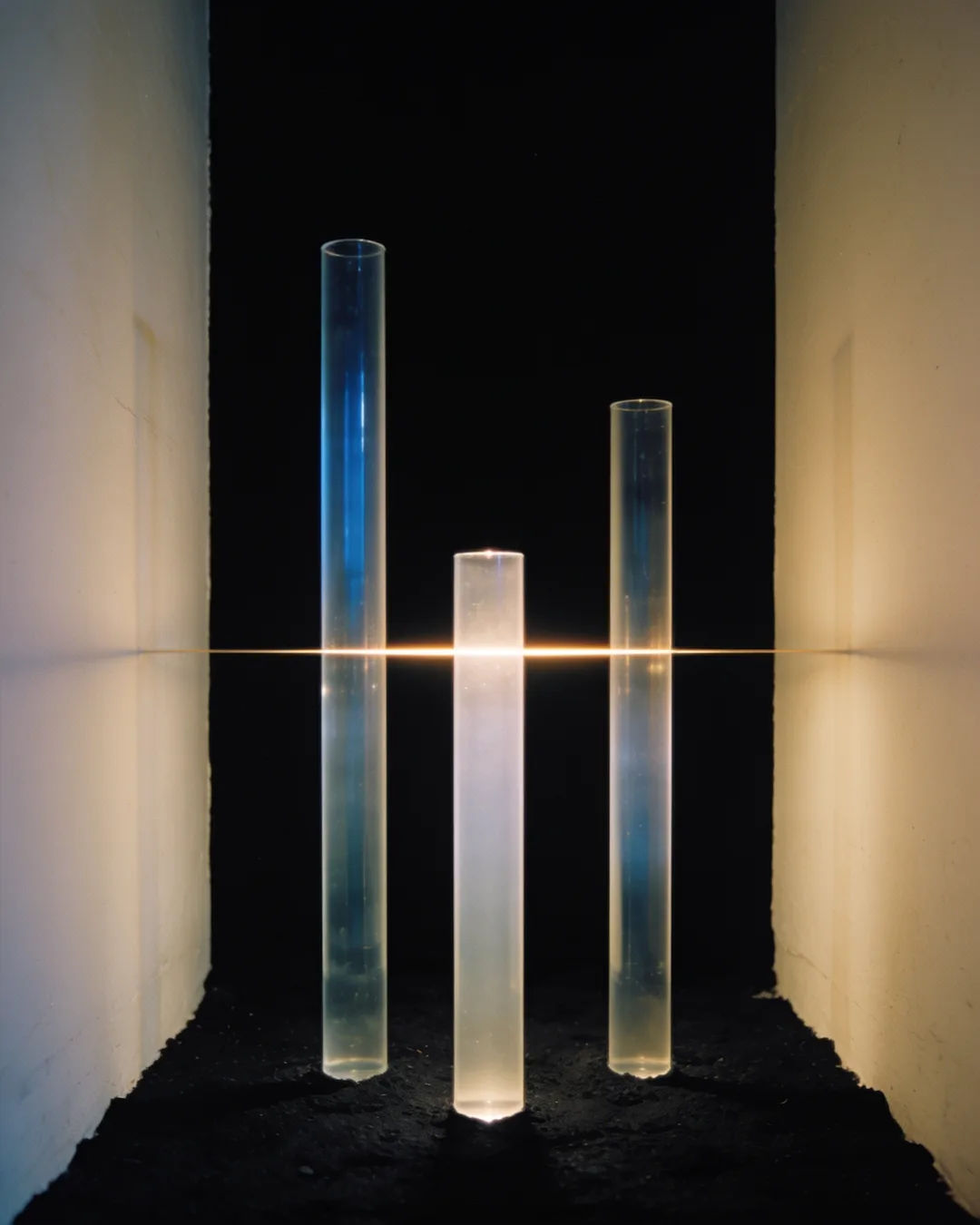 Glass columns of different heights with a glowing limit line