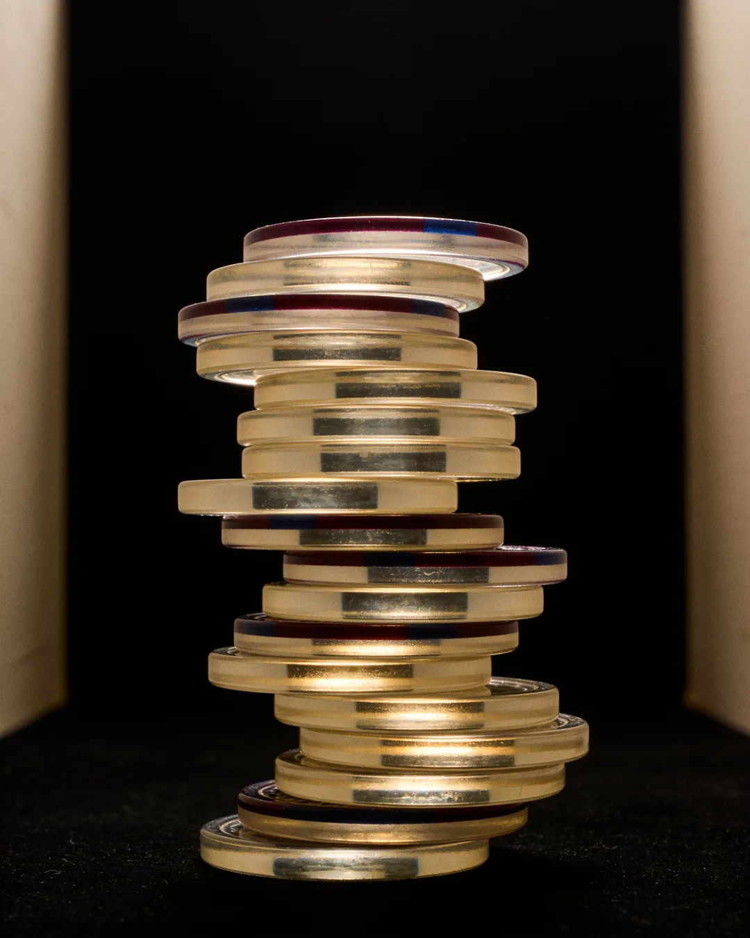 Stacks of glass tokens rising on a black ground