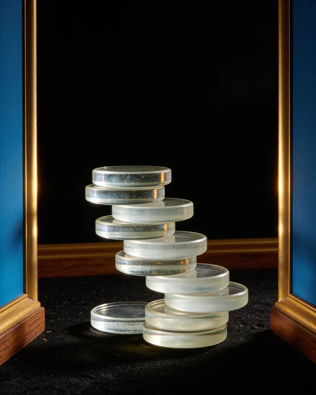 Stacks of glass tokens rising on a black ground