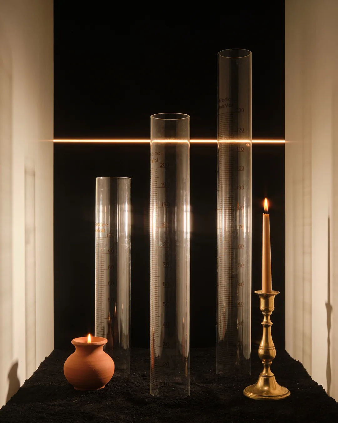 Glass columns of different heights with a glowing limit line