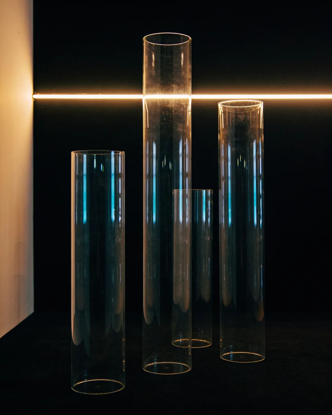Glass columns of different heights with a glowing limit line