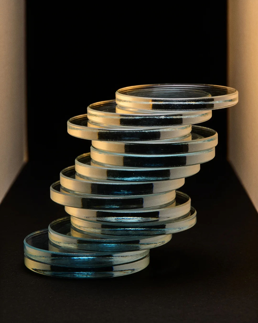 Stacks of glass tokens rising on a black ground