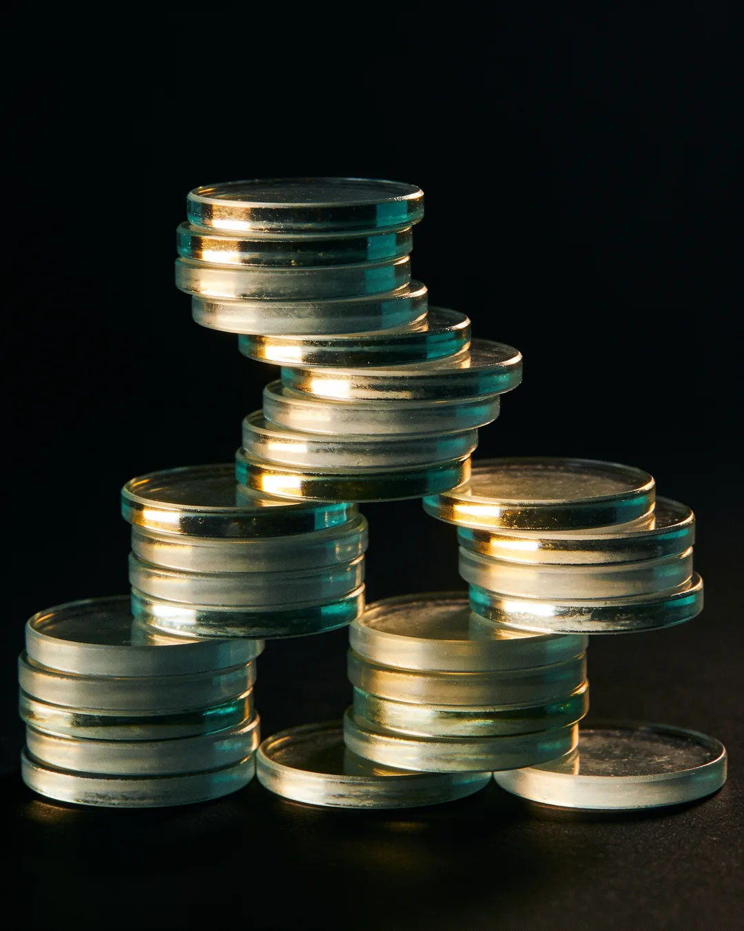 Stacks of glass tokens rising on a black ground