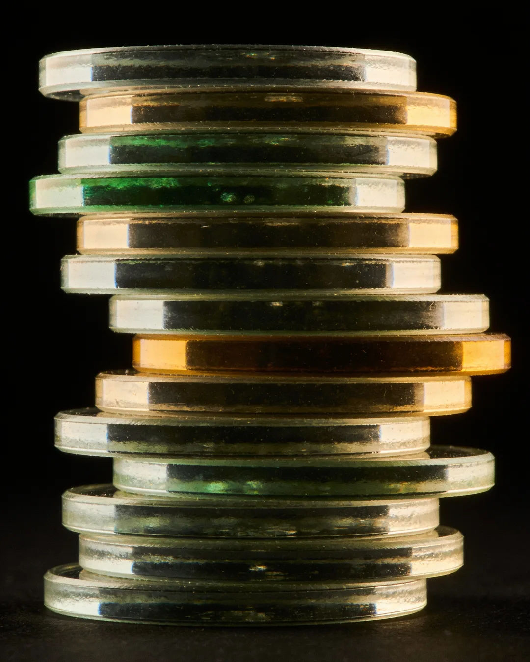 Stacks of glass tokens rising on a black ground