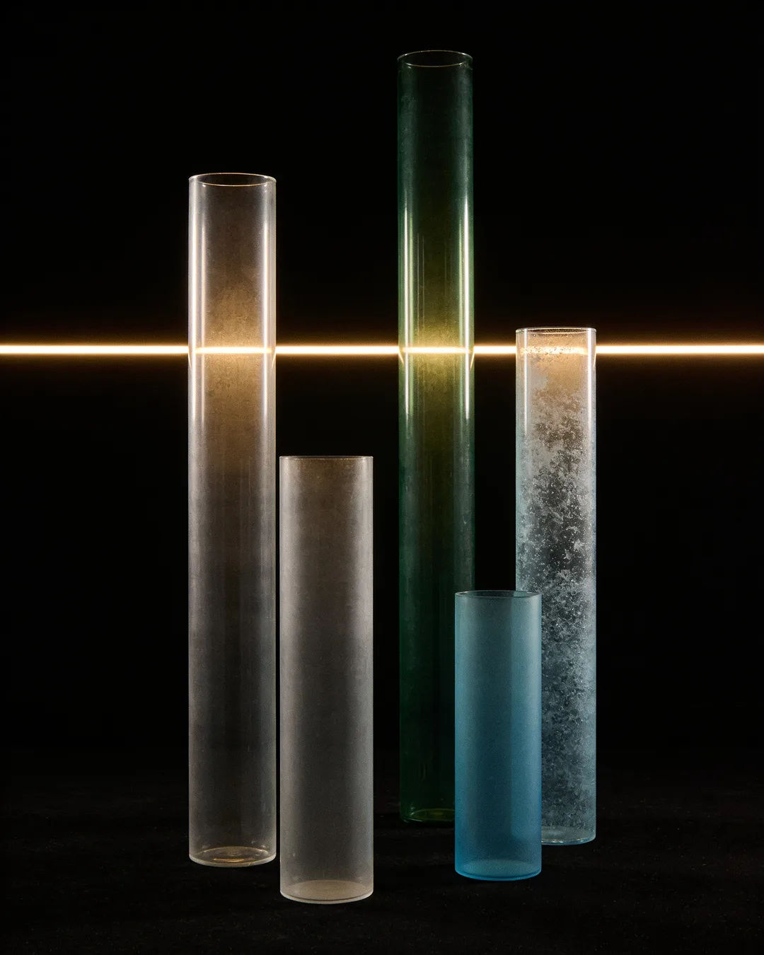 Glass columns of different heights with a glowing limit line