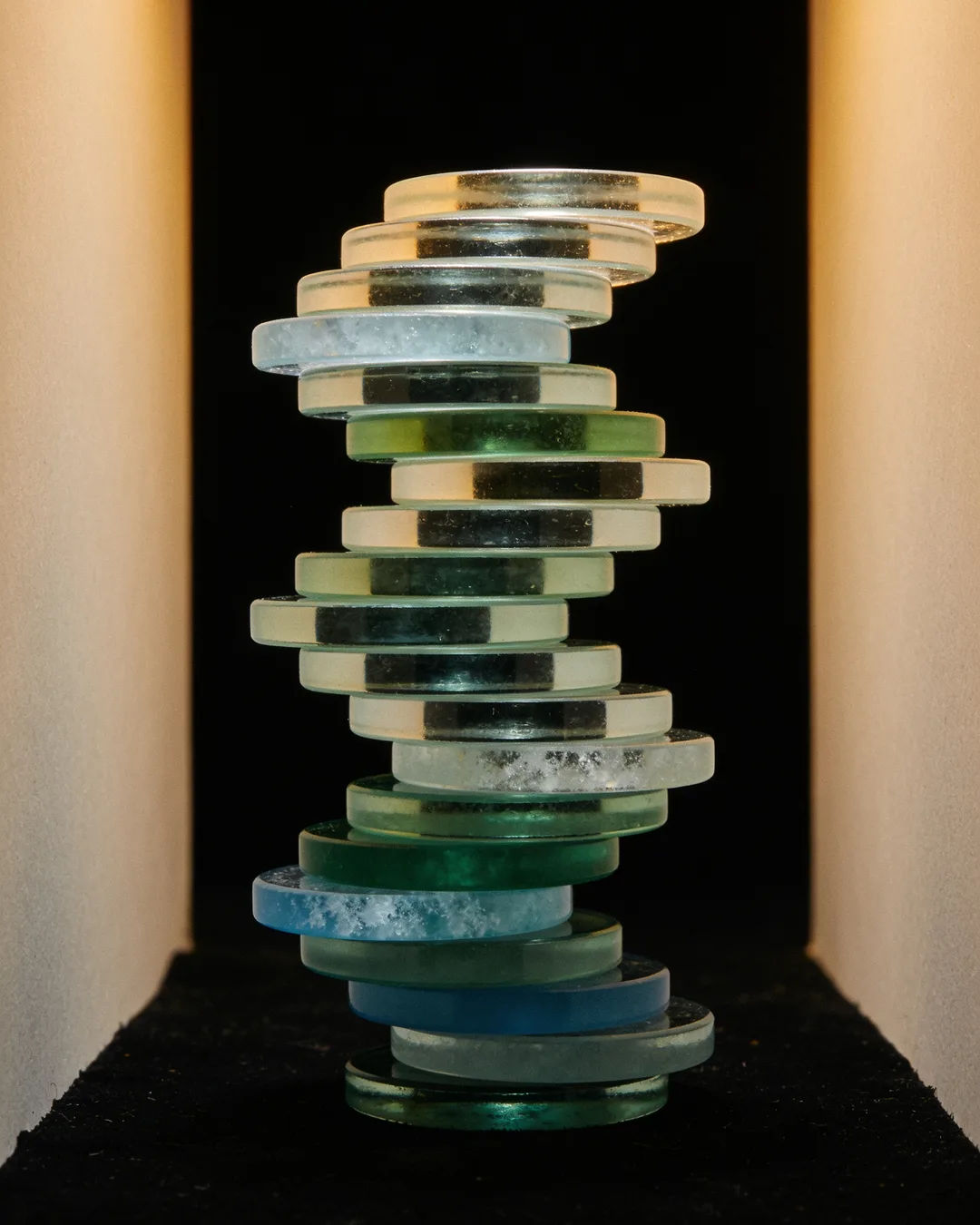 Stacks of glass tokens rising on a black ground