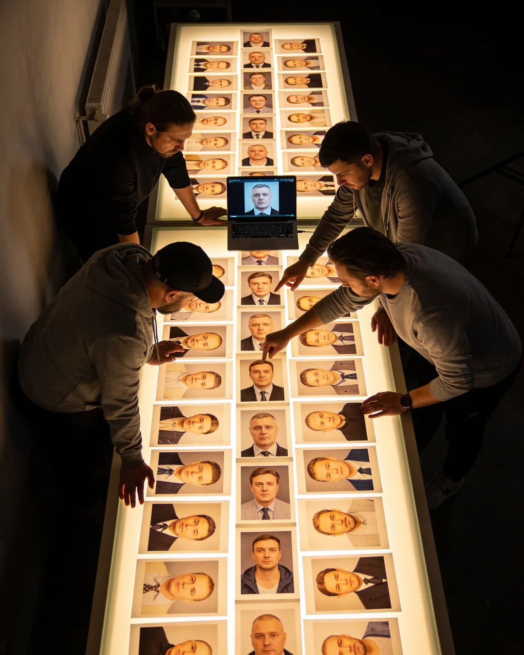 A Russian production team reviewing printed frames on a lit table