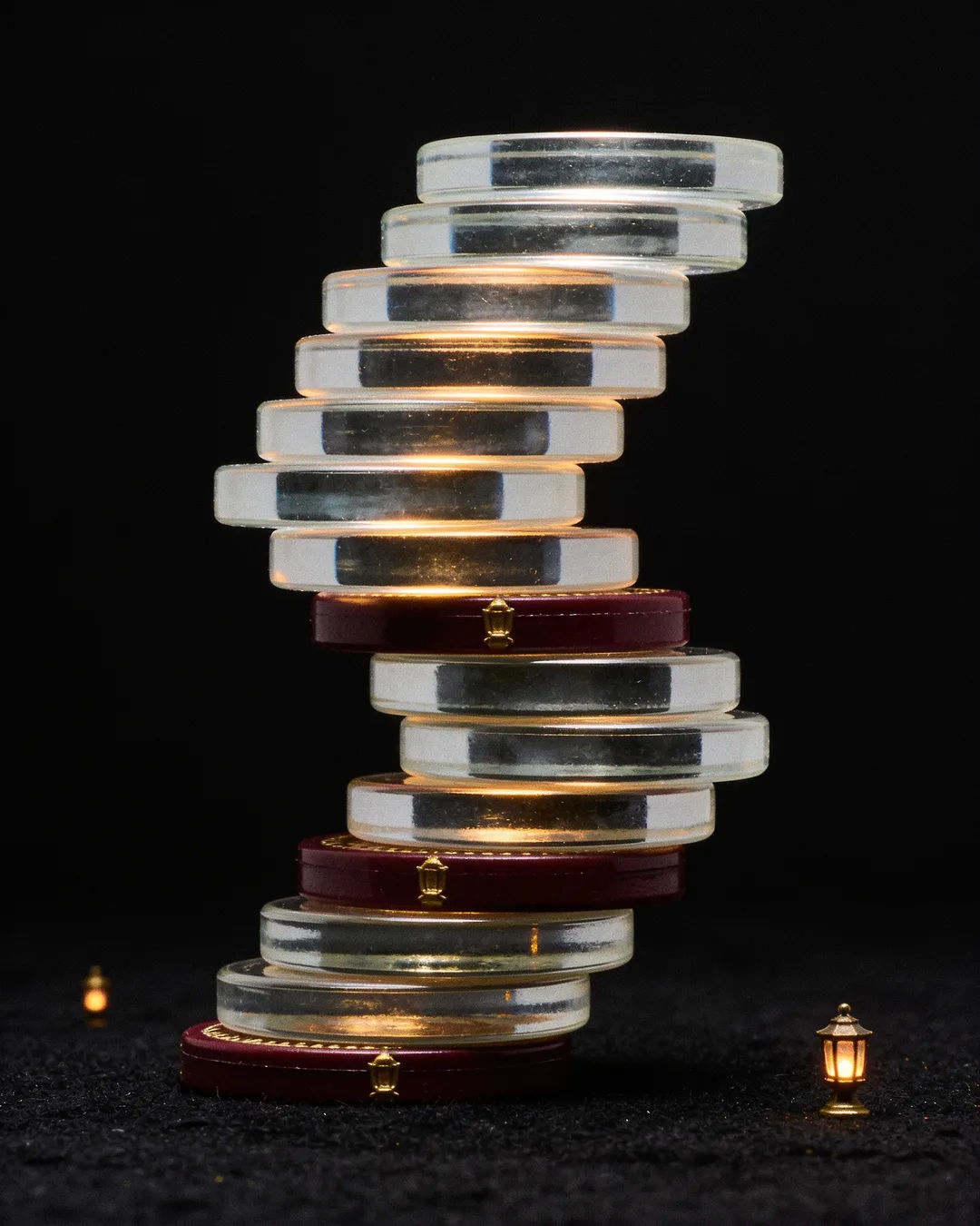 Stacks of glass tokens rising on a black ground