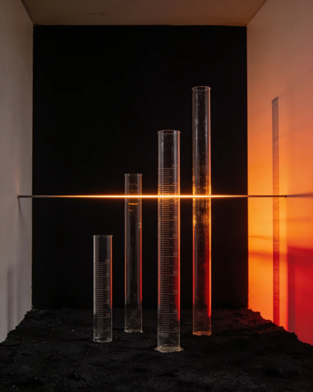 Glass columns of different heights with a glowing limit line