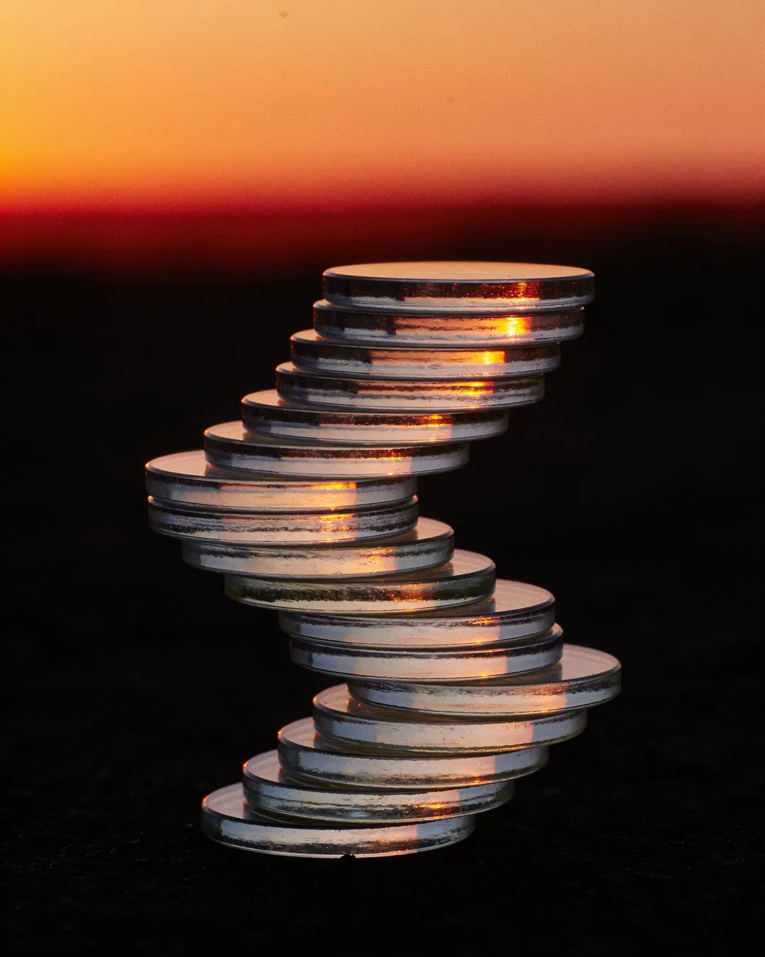 Stacks of glass tokens rising on a black ground
