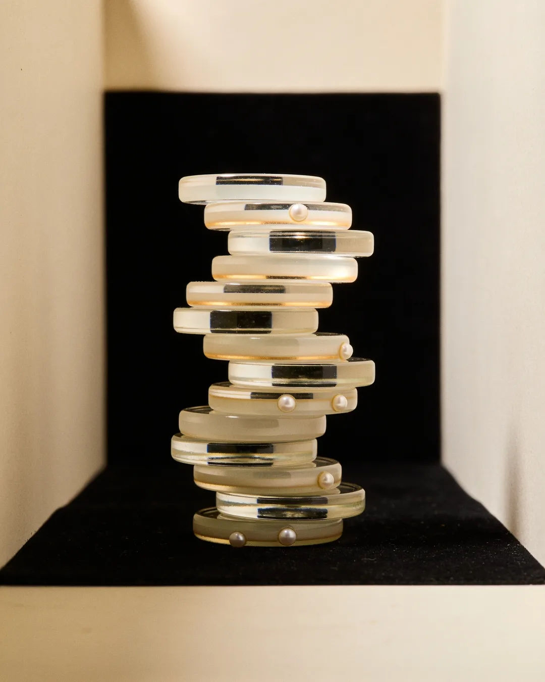 Stacks of glass tokens rising on a black ground