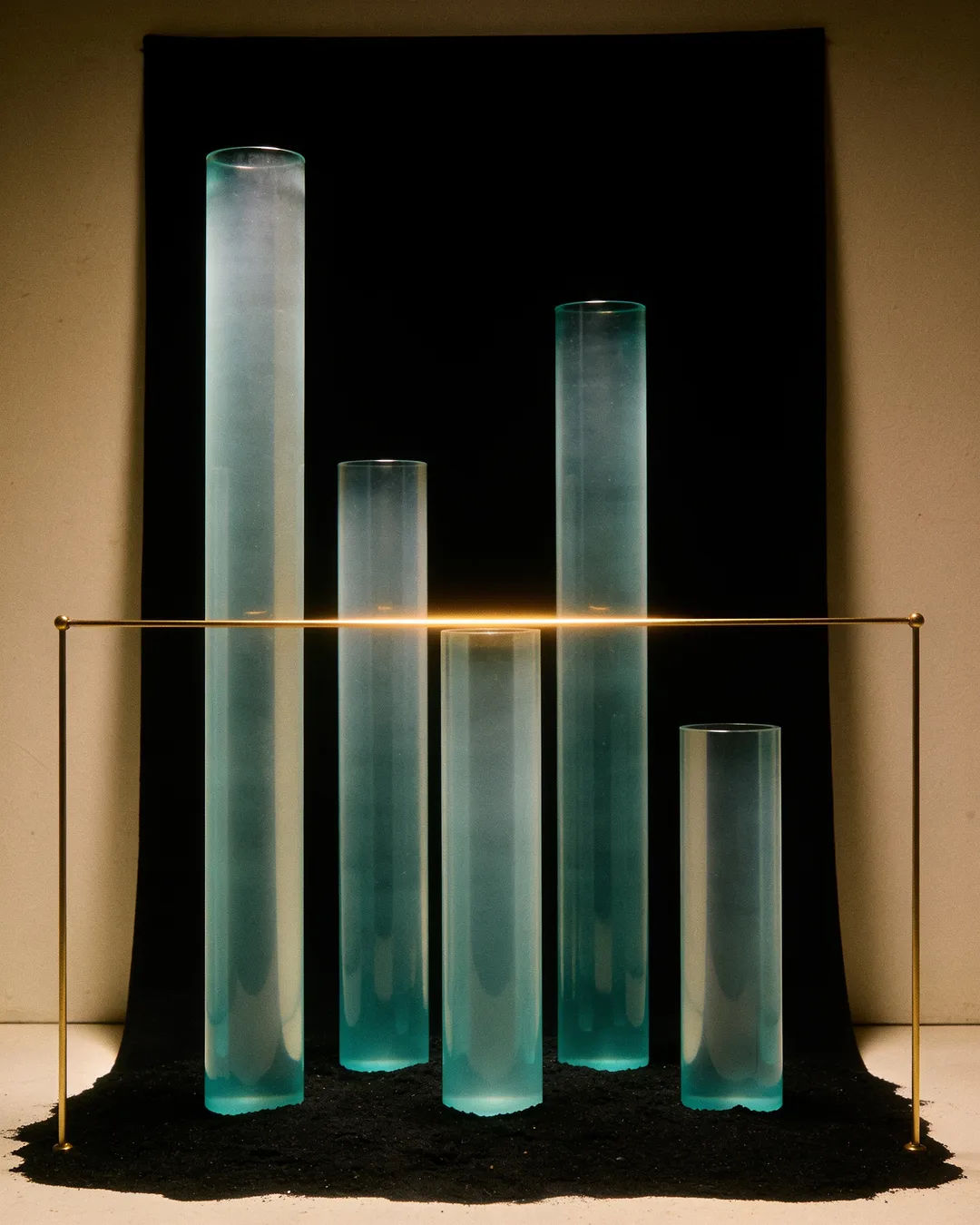 Glass columns of different heights with a glowing limit line