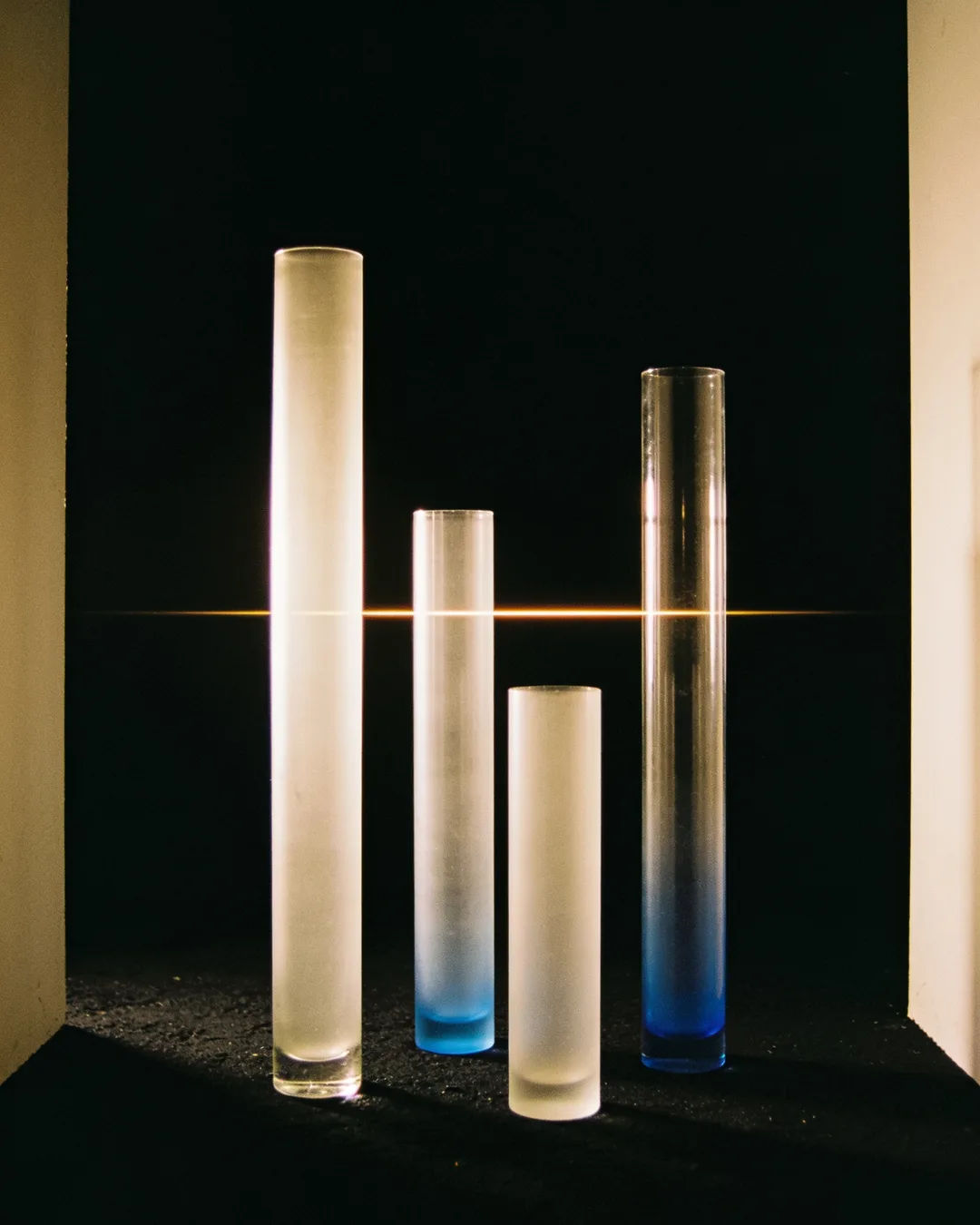 Glass columns of different heights with a glowing limit line