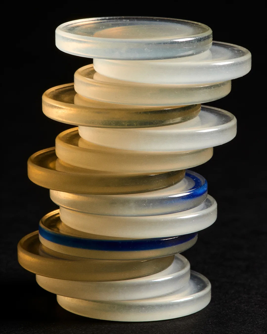 Stacks of glass tokens rising on a black ground