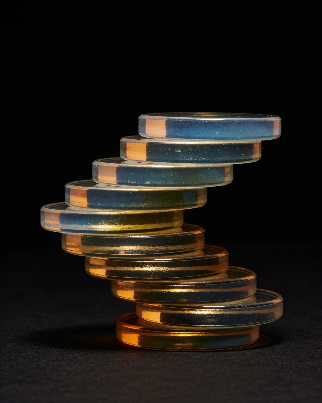 Stacks of glass tokens rising on a black ground