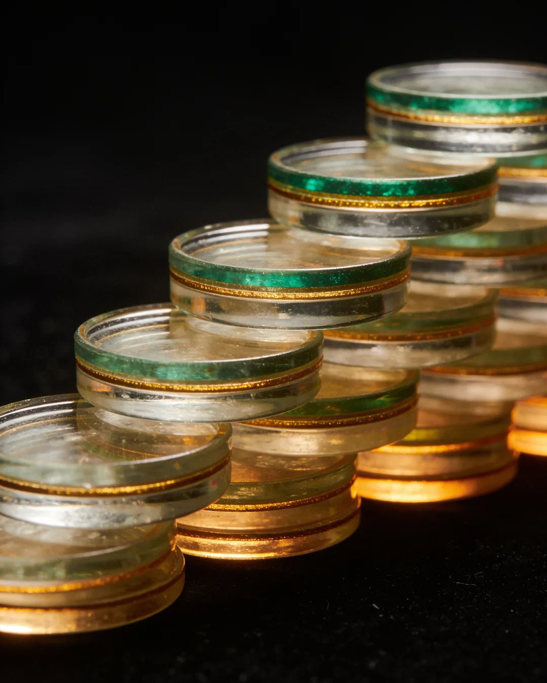Stacks of glass tokens rising on a black ground