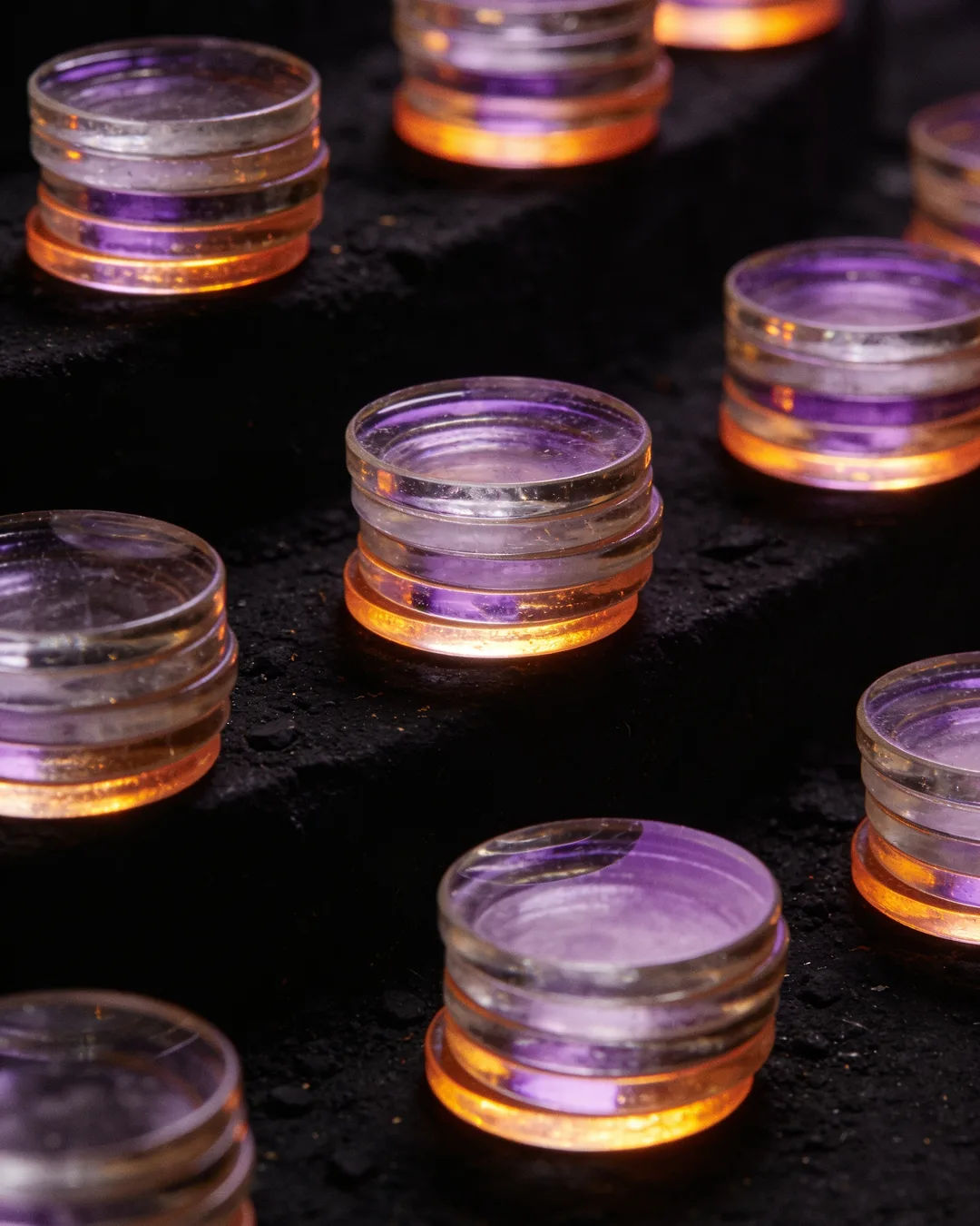 Stacks of glass tokens rising on a black ground