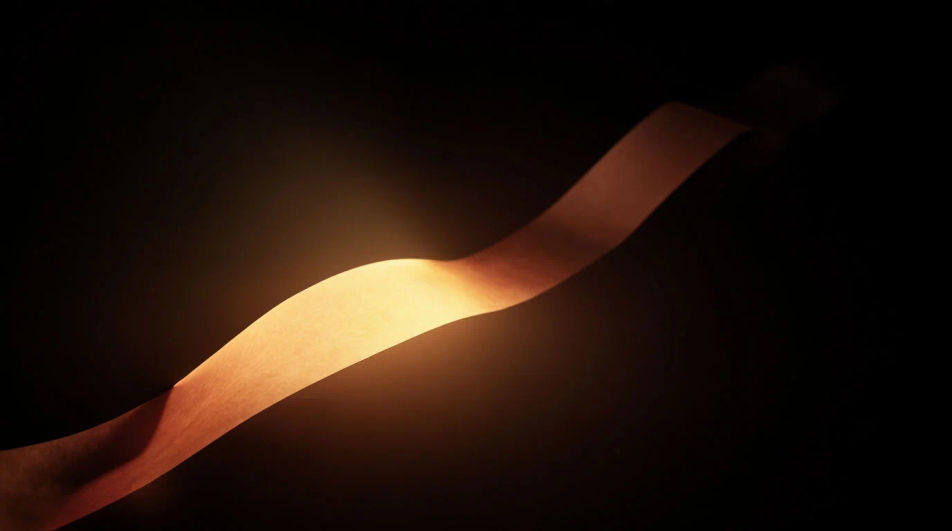 A long ribbon of warm amber light unspooling slowly into deep black