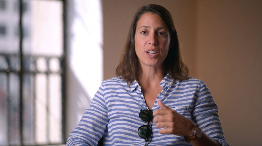 A woman speaking to camera mid-sentence in soft window light