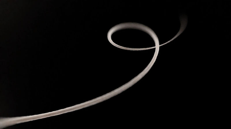 A single soft thread of warm ivory light curling once