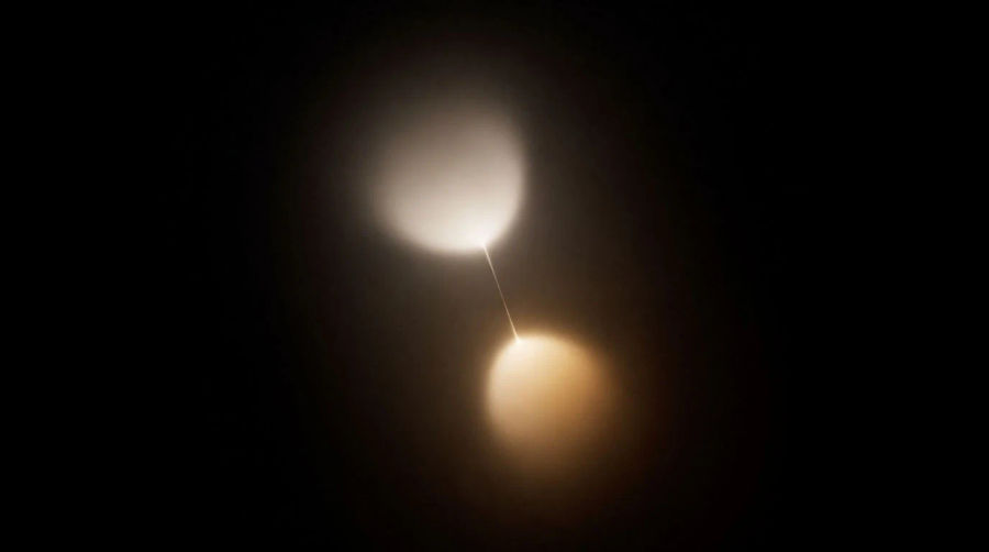 Two glowing nodes joined by a taut thread of light, one answering the other
