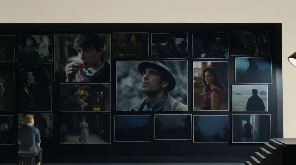 A wall of framed cinematic film stills arranged in a grid above a studio desk